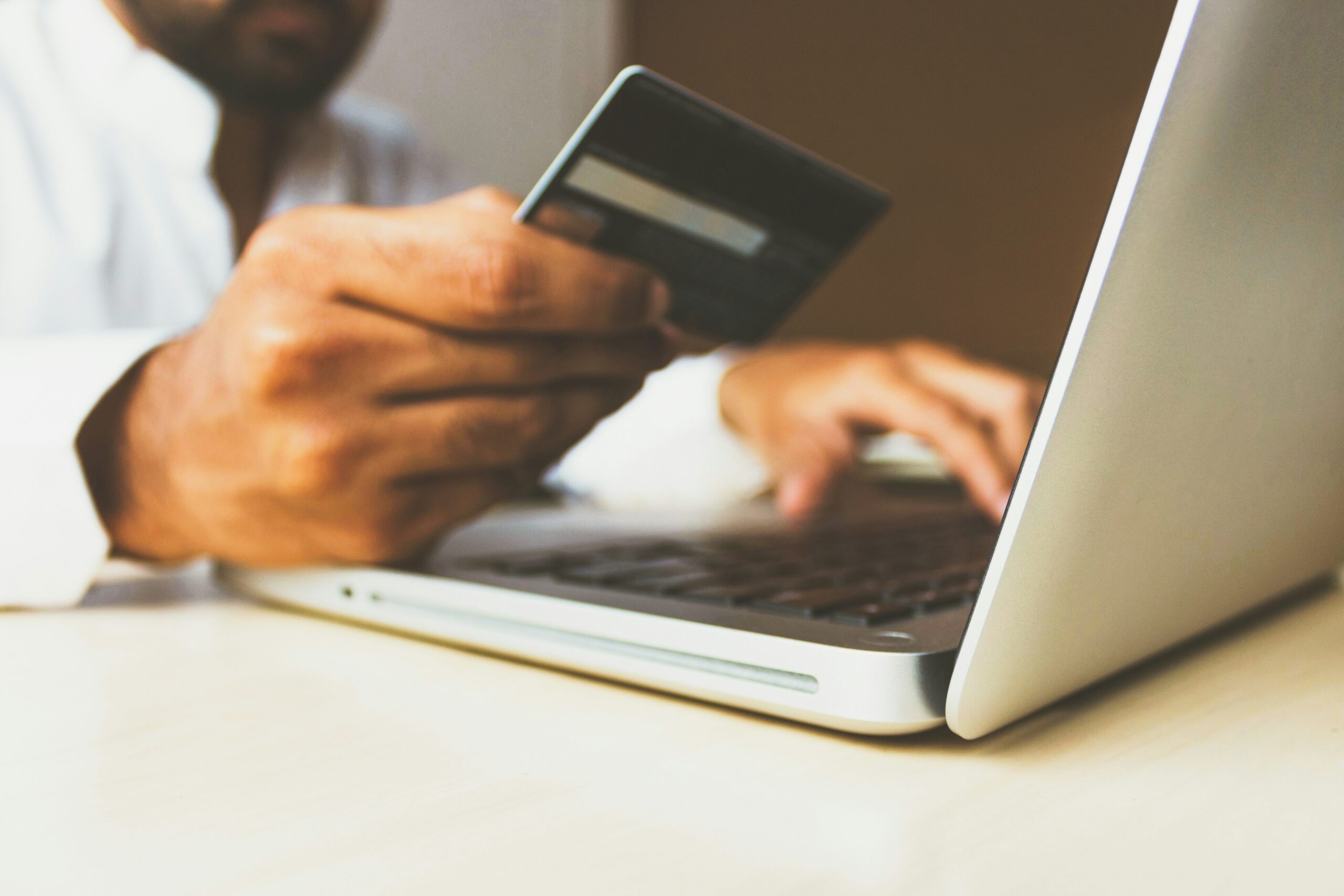 Person putting credit card details into laptop.