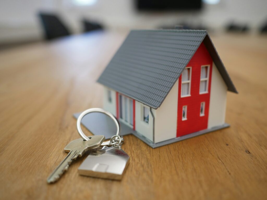 Miniature house next to a key.