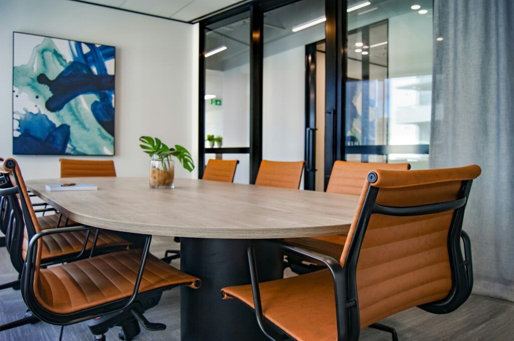 Empty table with chairs in office room with glass wall.